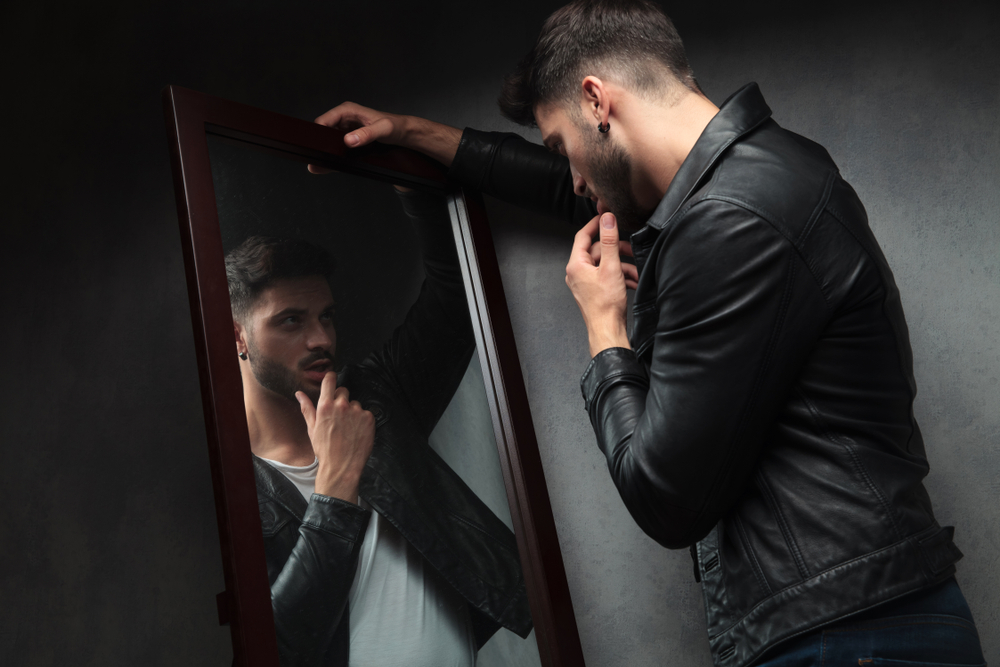 man admiring himself in mirror
